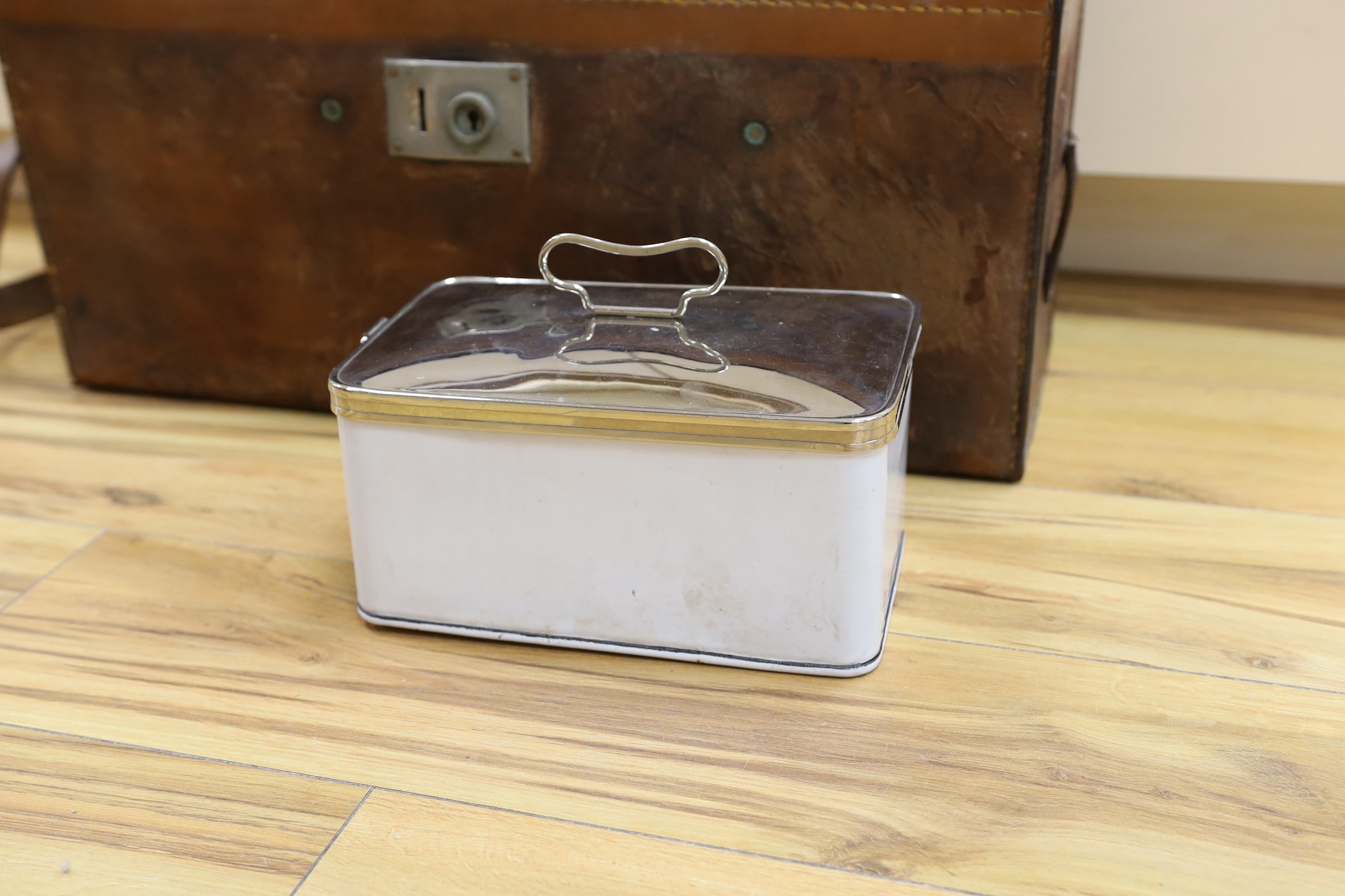Automobilia related - an early leather cased car picnic hamper, with enamelled plates, basket work covered glass bottles and tumblers and plated cutlery